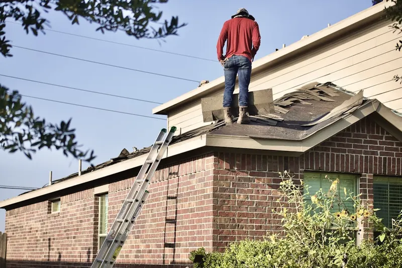 Professional roofer working on a residential roof in Framingham